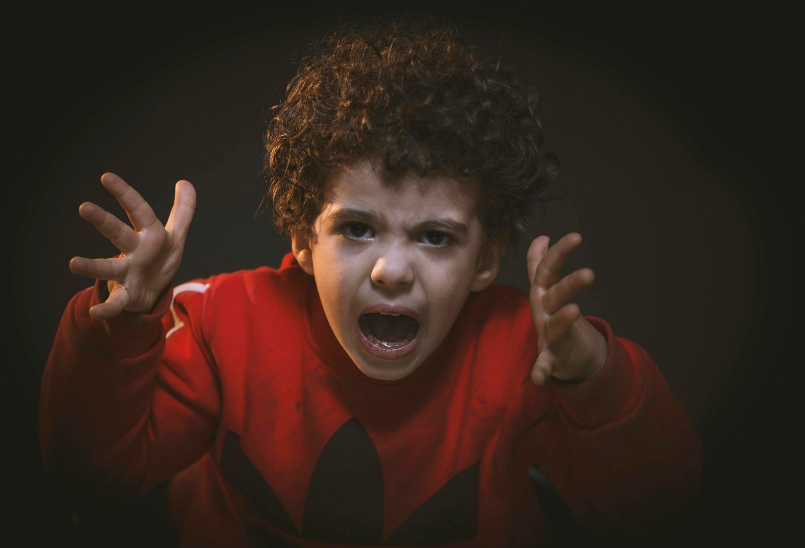 A young child expressing strong emotions during a studio portrait shoot.